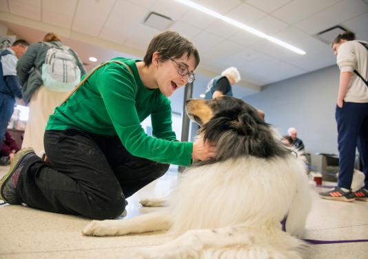 A student petting a therapy dog.