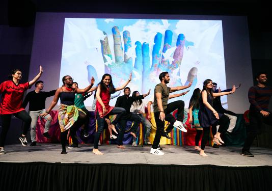 Students dancing together to a mix of songs from different genres and cultures.