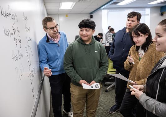 A professor instructing a small group of students.