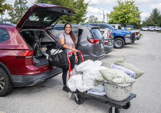 A student is moving personal items on a cart
