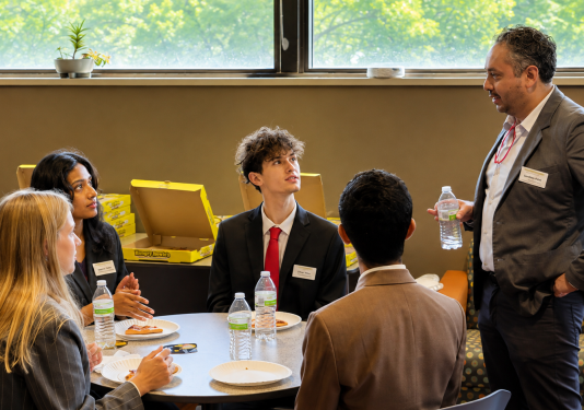 Photo of professor speaking with students.