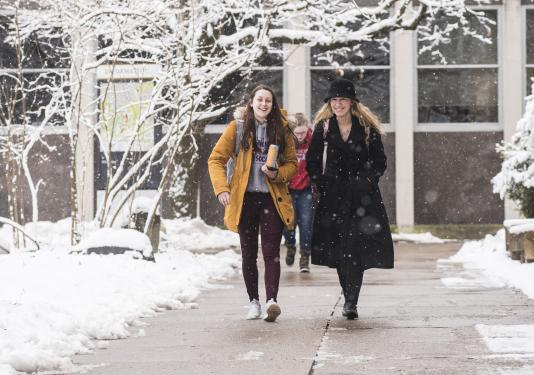 Students walking and discussing their class notes.