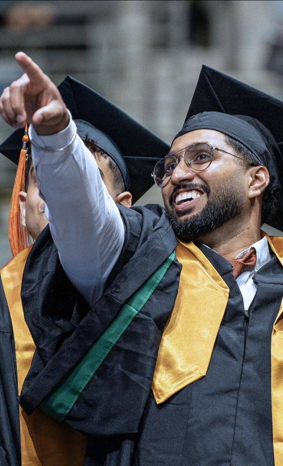 A student pointing to the crowd during the 2026 commencement ceremony