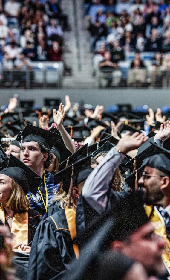 Students wave at the 2026 commencement ceremony