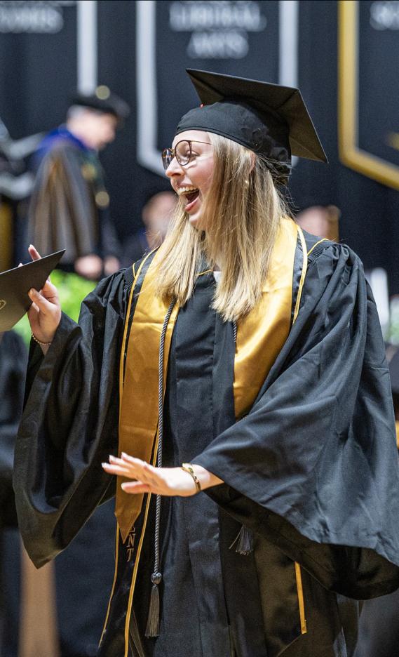 A female student walks down the aisle at the 2026 commencement ceremony