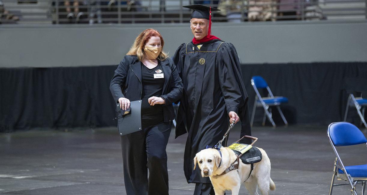 Jim Platzer and his leader dog, Maggie, at the 2021 commencement ceremony