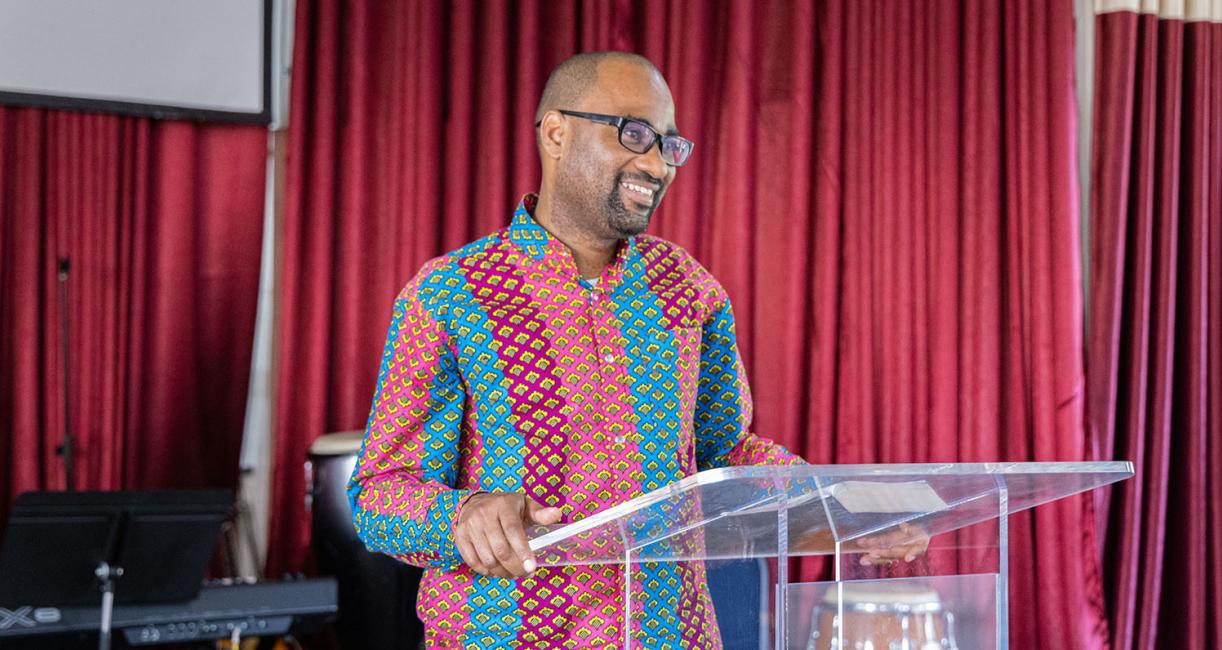 Francois Mikobi is standing behind a church lectern.