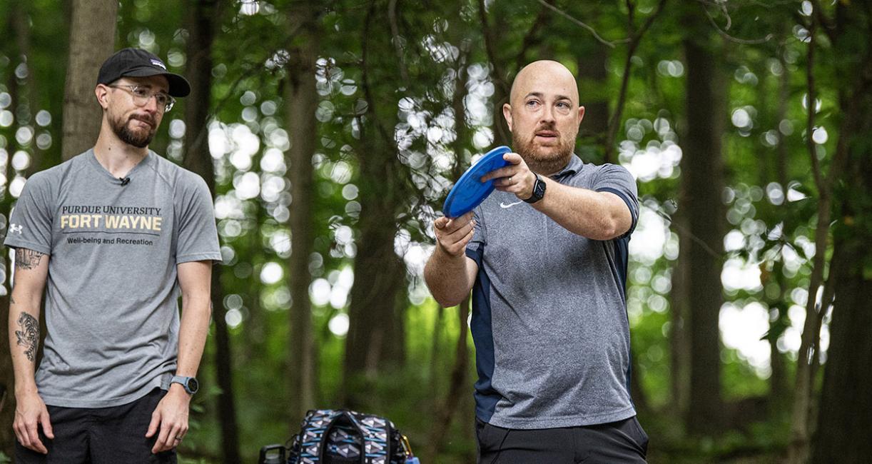 Nick Brand and Brian Spaulding are playing disc golf.