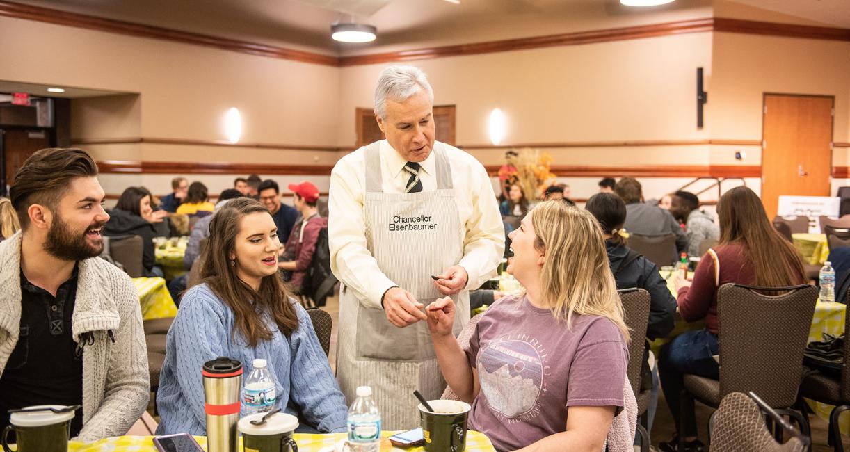 Chancellor Ron Elsenbaumer visits a table at Chili Fest.