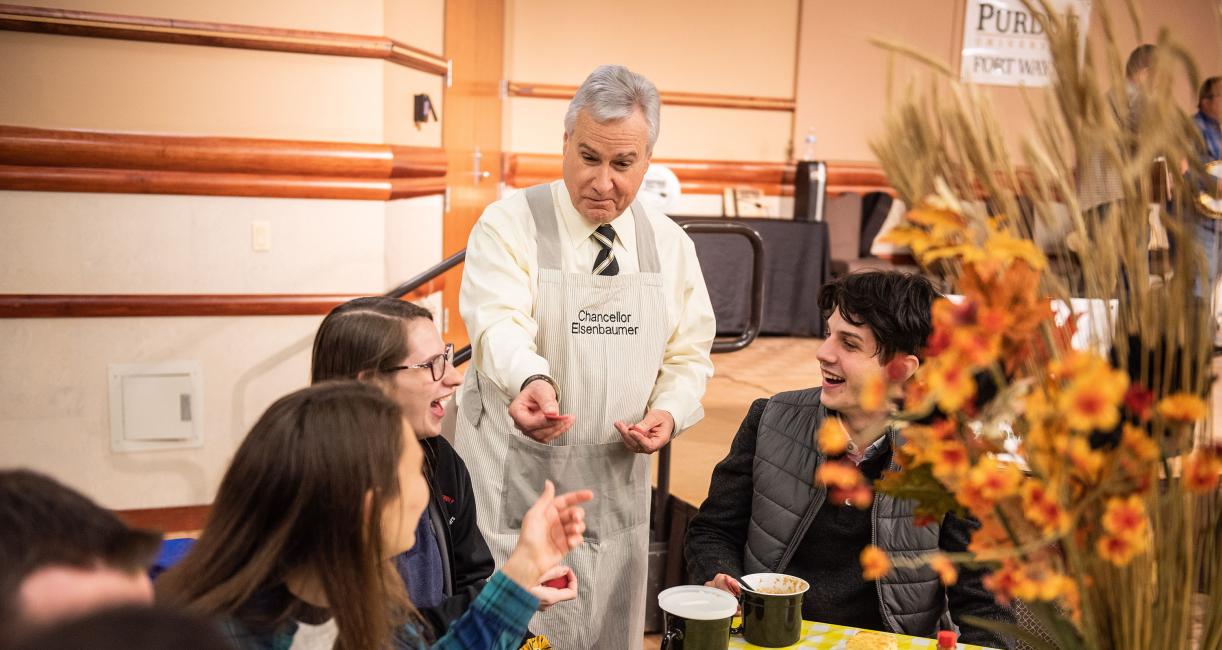 Chancellor Ron Elsenbaumer visits a table at Chili Fest.