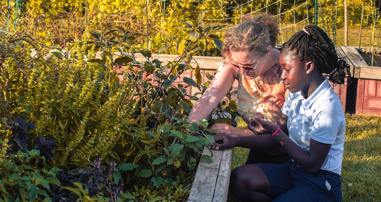 An adult and child are working in the School of Education's urban garden.