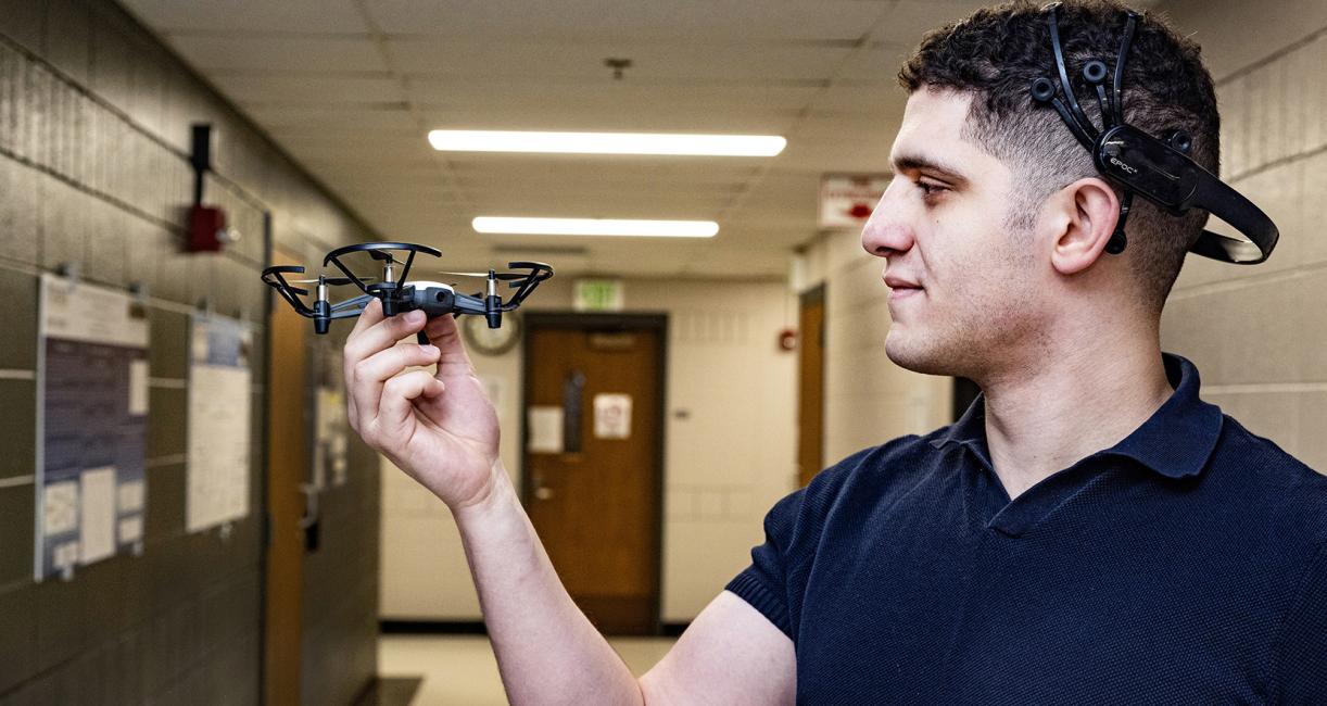 Abdelrahman Gad inspects a small, four-propeller drone.