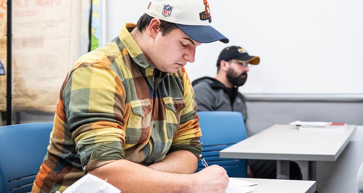 Student reading a paper in class