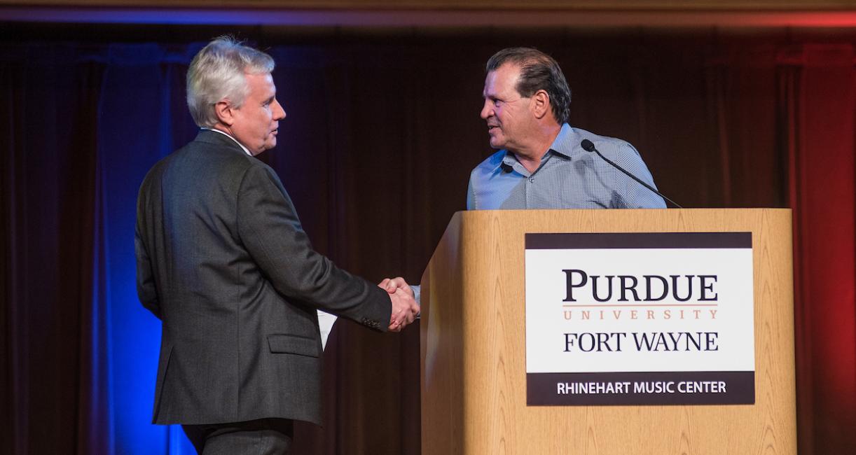 Chancellor Ron Elsenbaumer shakes hands with Mike Eruzione.