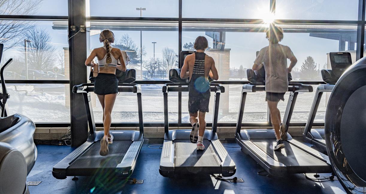 Three students running on treadmills