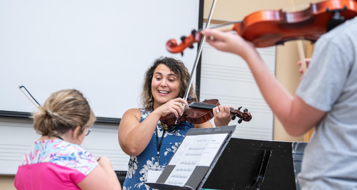 woman educating violin students