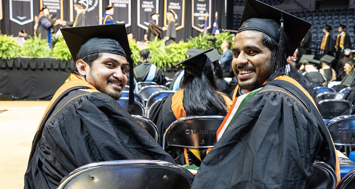 Two graduate looking behind them