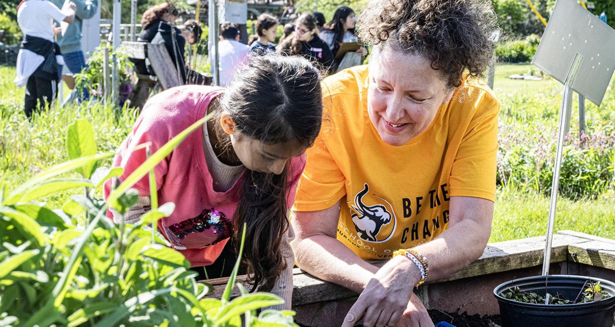 A teacher and student are working in a garden