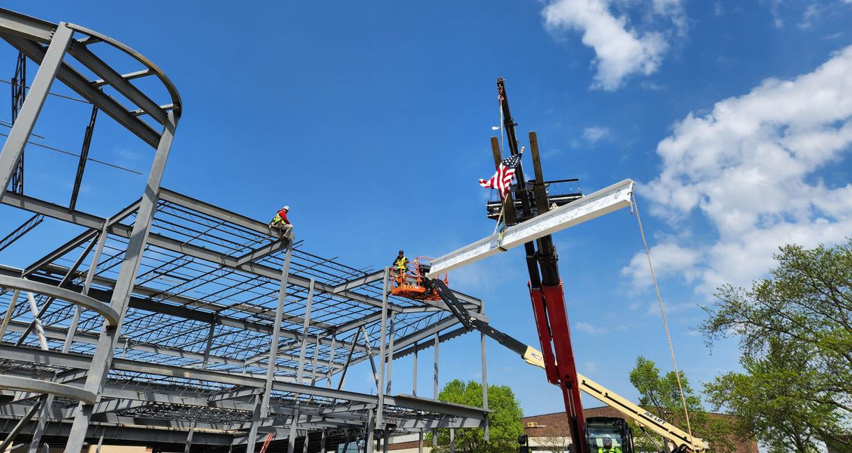 The final beam is being hoisted to the top of the Music Industry Building