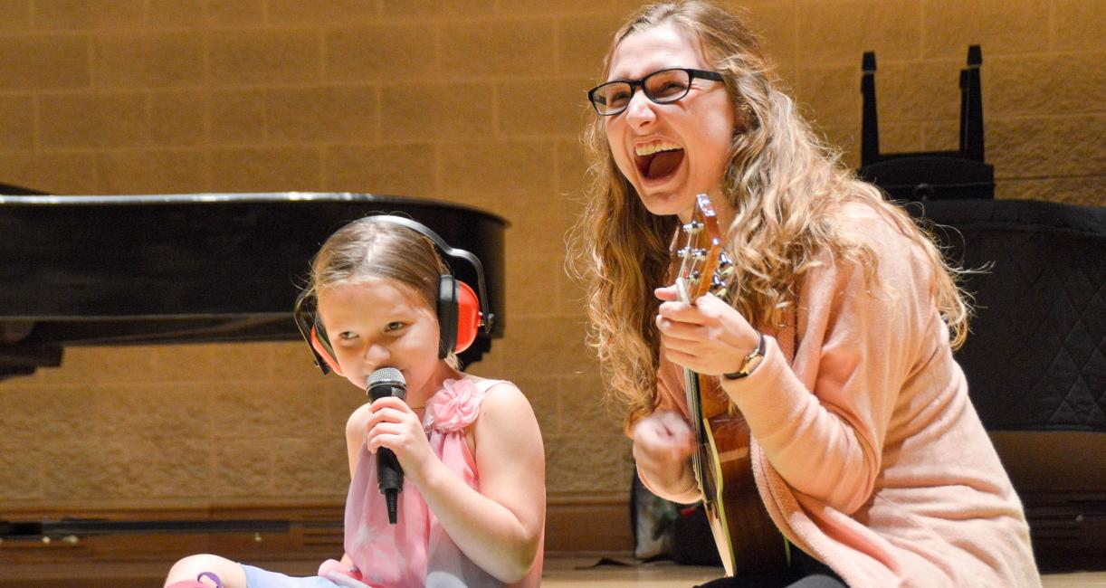 A music therapist is performing with a client