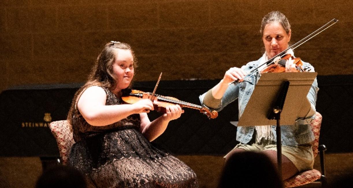 A music therapist is performing with a client