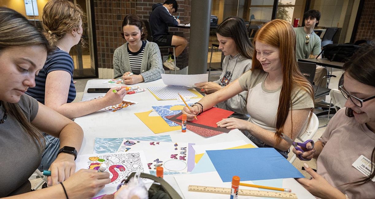 Students are crafting while sitting at a table