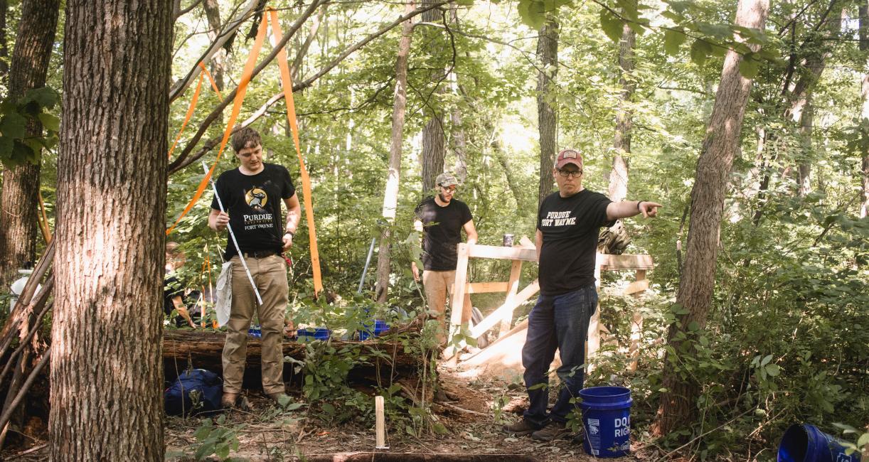 Students stand at a dig site during field school