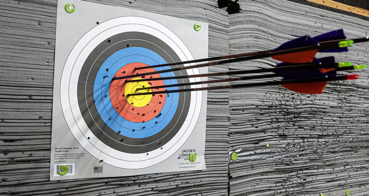 An archery target with several arrows near the middle