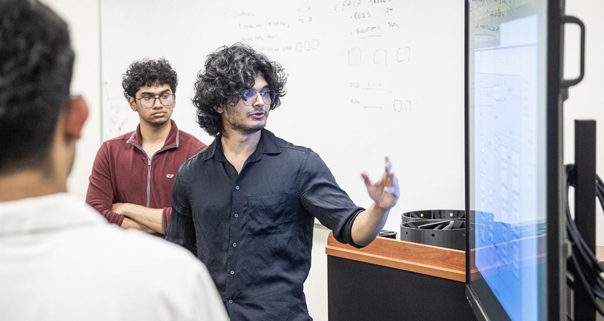 A student is gesturing at a video display