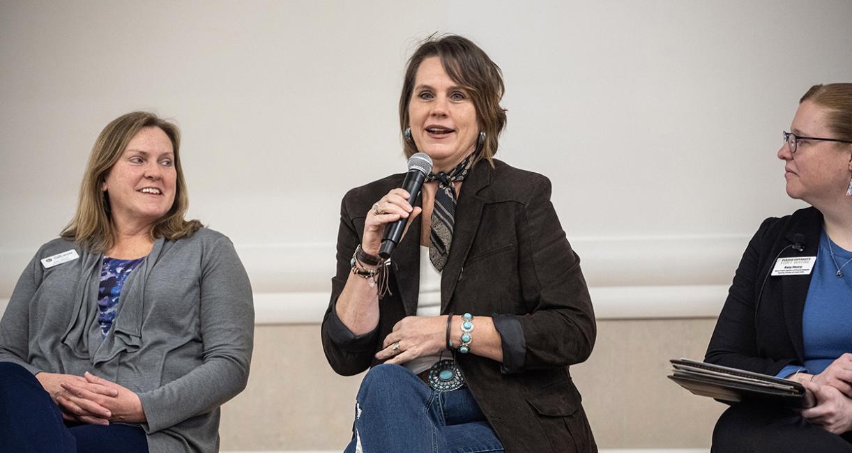 A women is speaking into a microphone