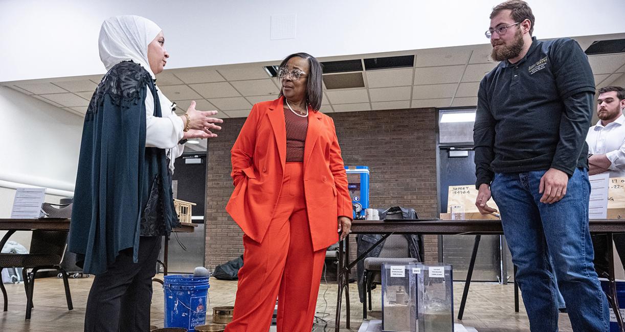 Mayor Sharon Tucker is talking to attendees at a conference