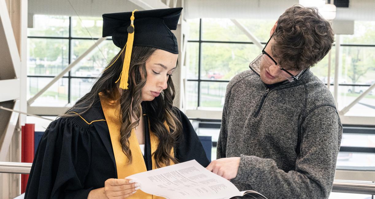 Two students prepare for the 2026 commencement ceremony