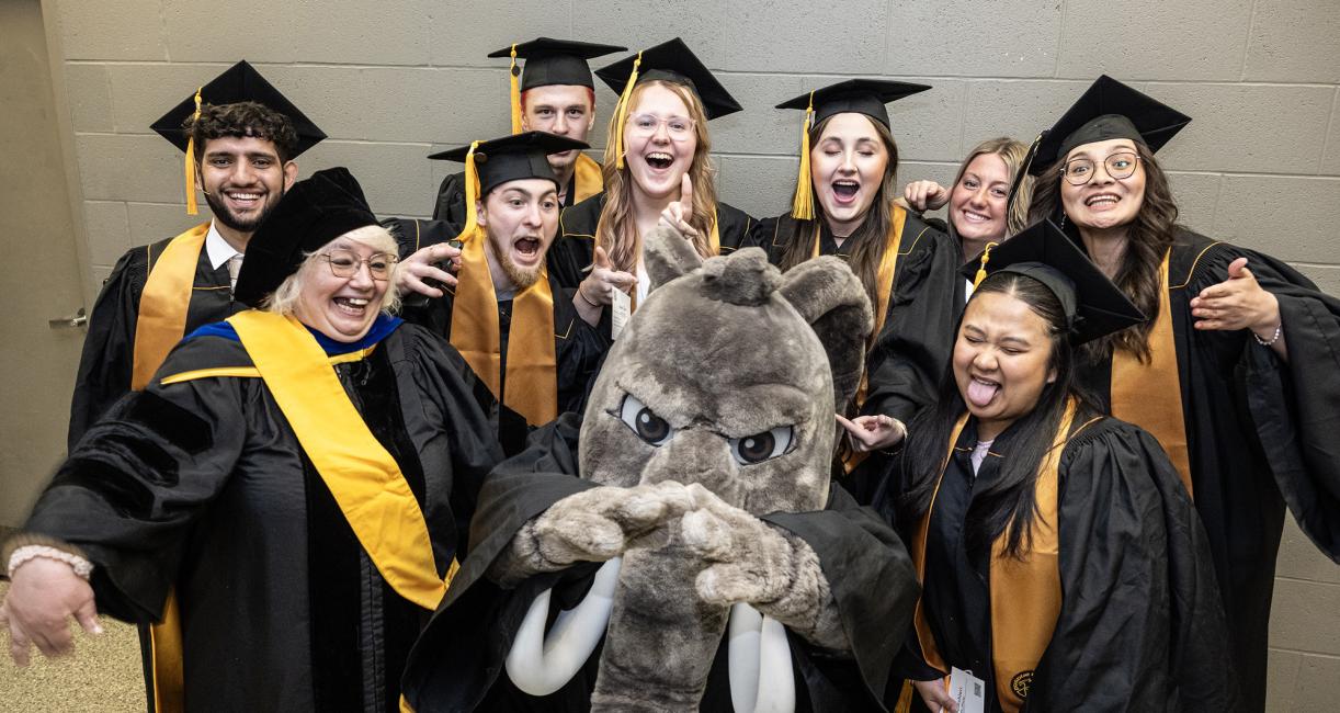 Don poses with students during the 2026 PFW commencement ceremony