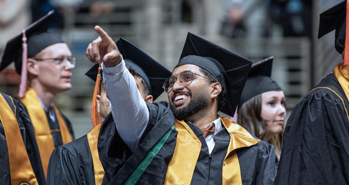 A student pointing to the crowd during the 2026 commencement ceremony