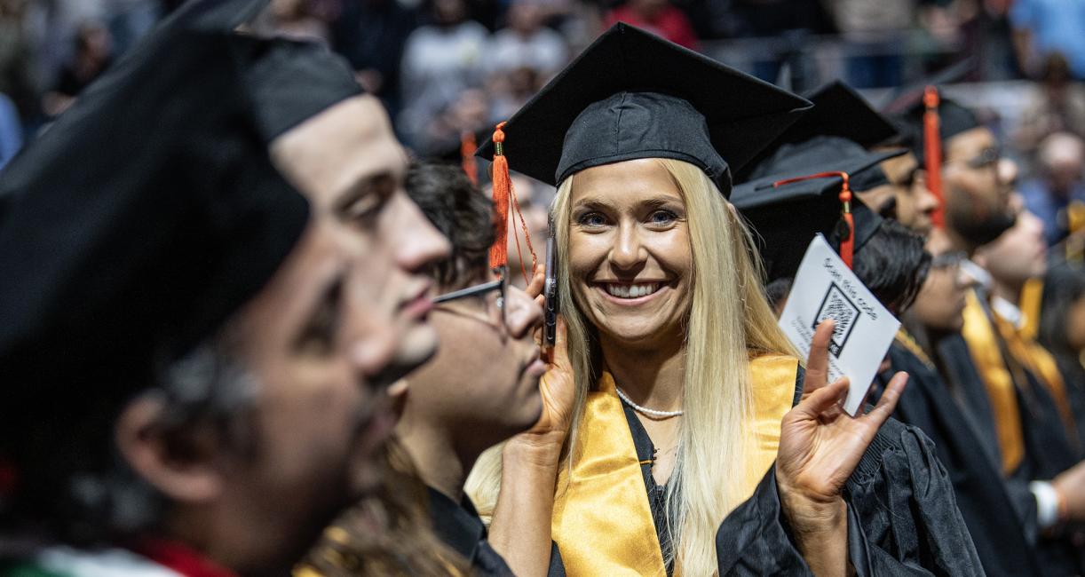 Student waves during the 2026 commencement ceremony