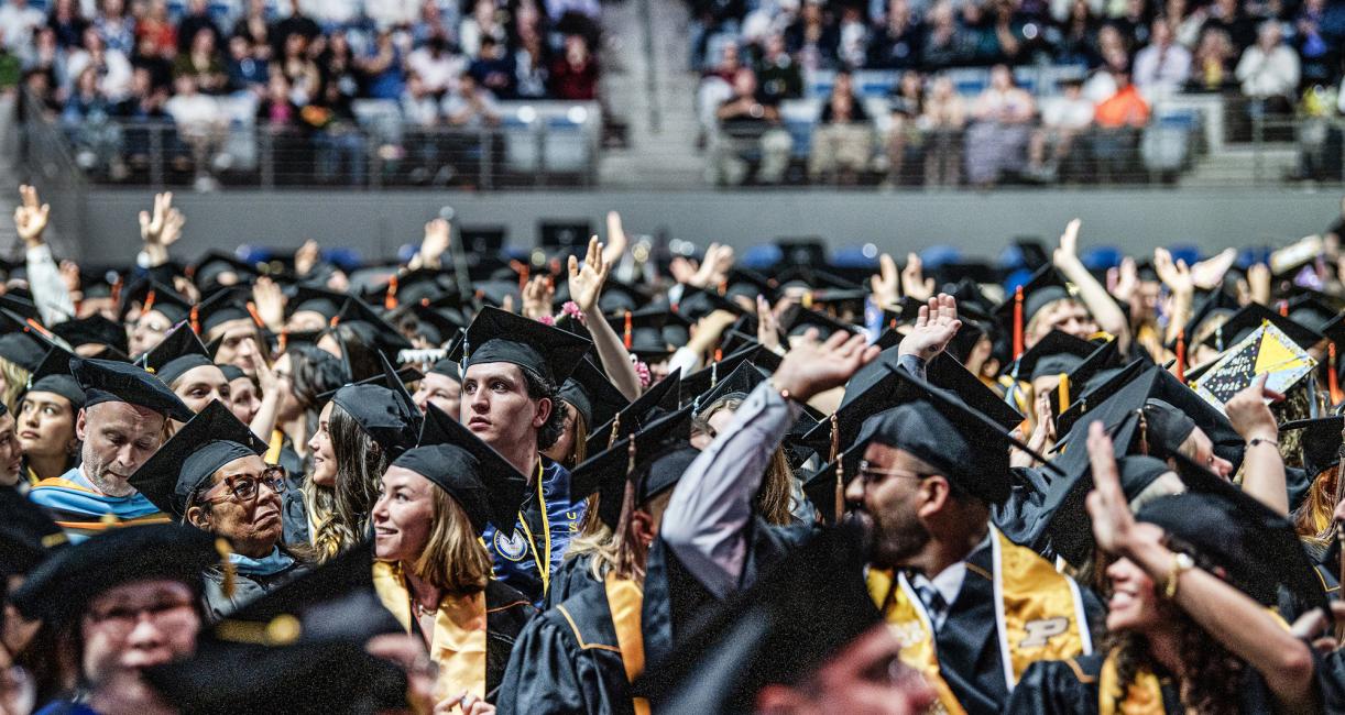 Students wave at the 2026 commencement ceremony