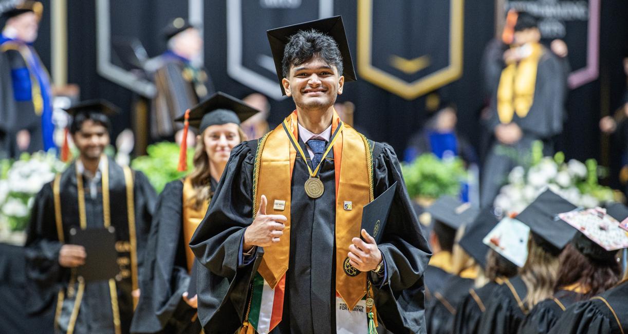 A student walks down the aisle at the 2026 commencement ceremony