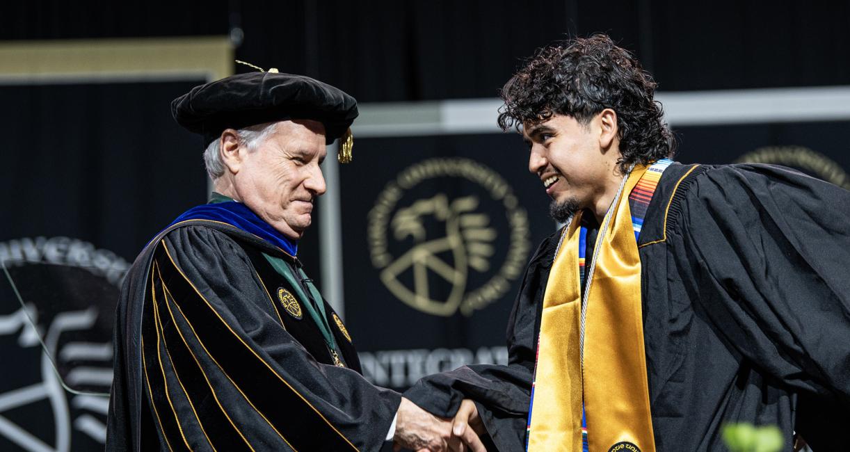 The Chancellor and a student shake hands at the 2026 commencement ceremony