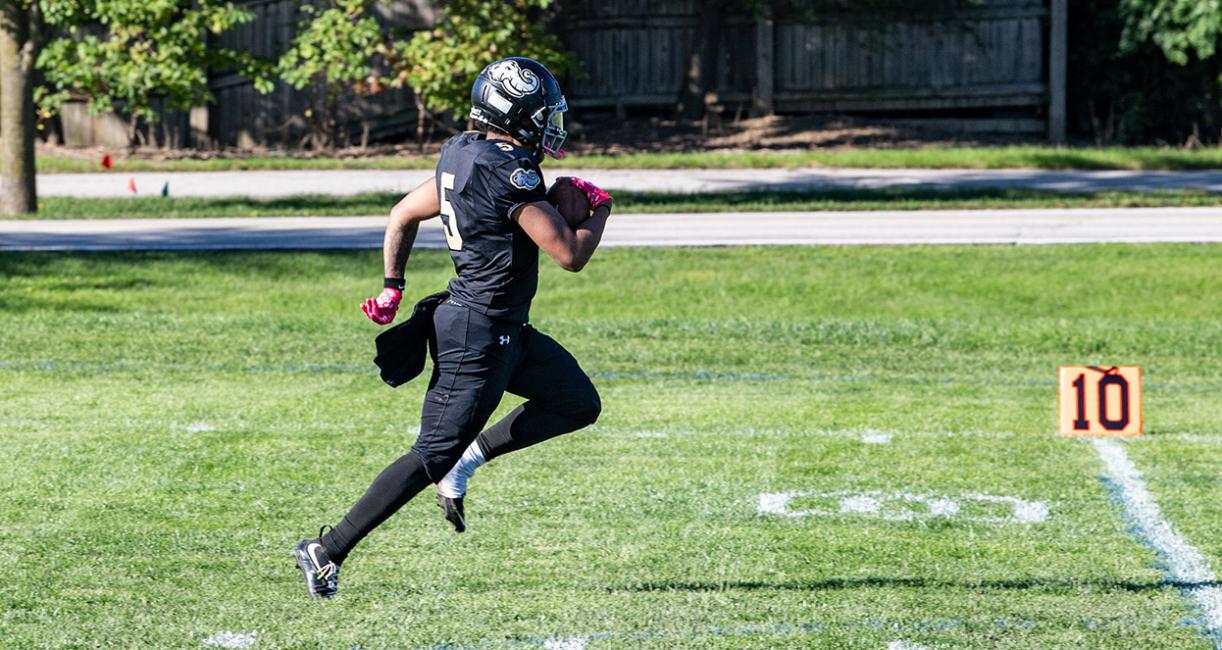 A football player is running with the ball