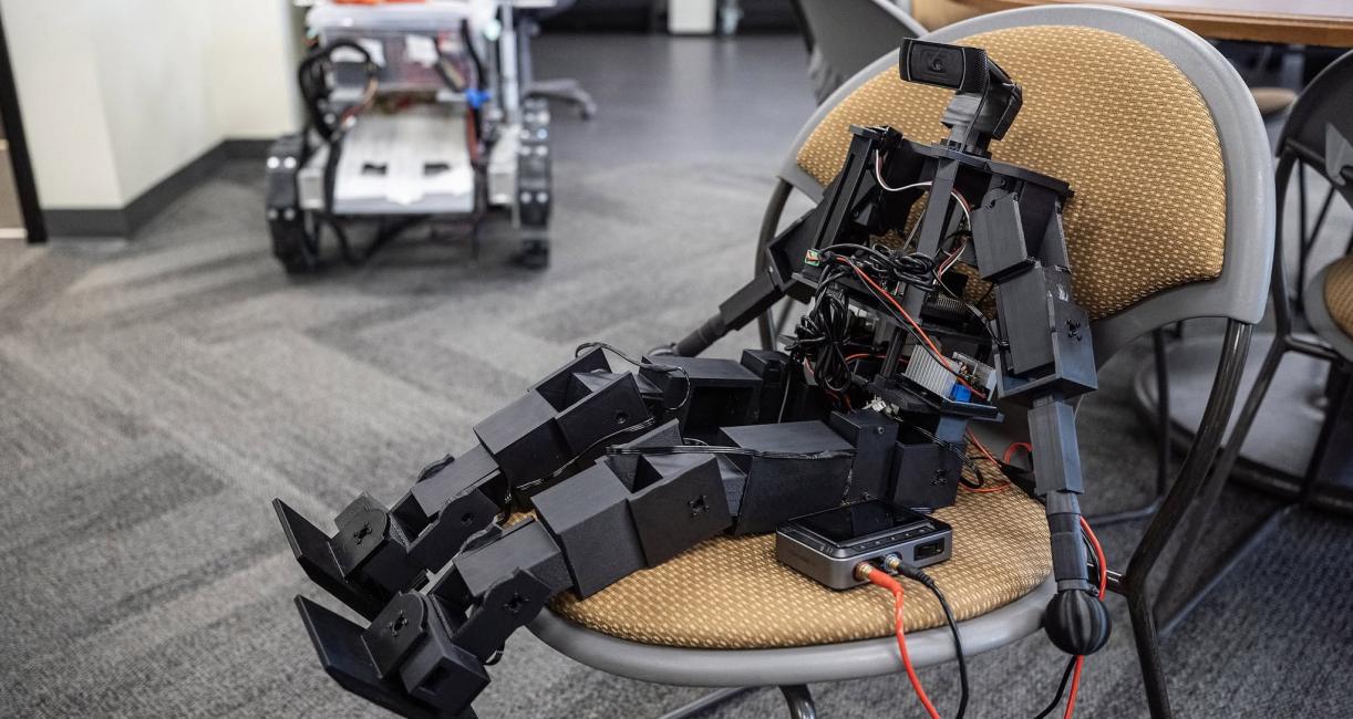 A robot is siting on a chair