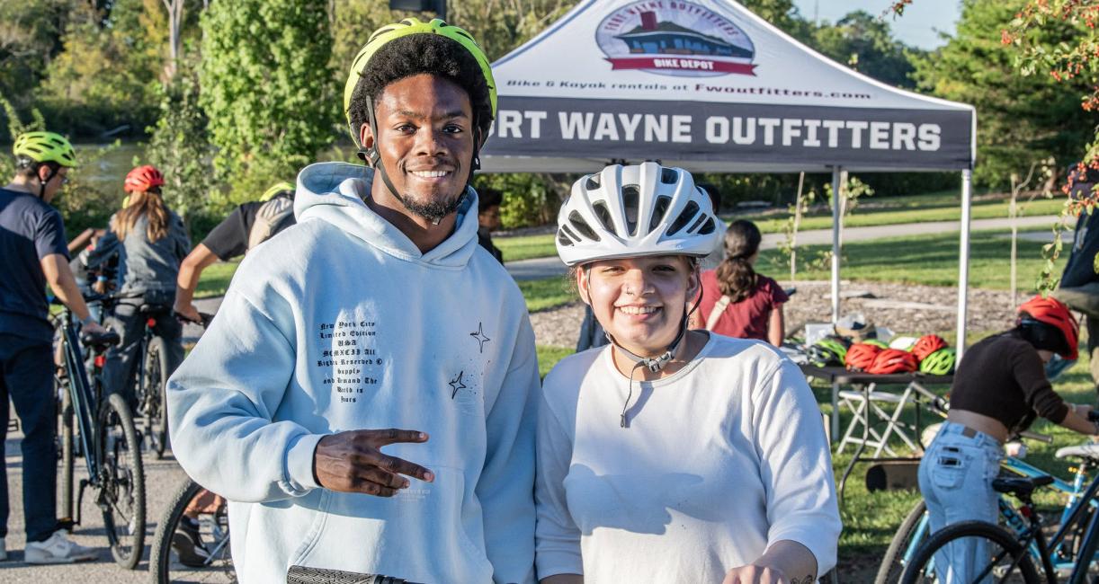 Two people wearing bike helmets