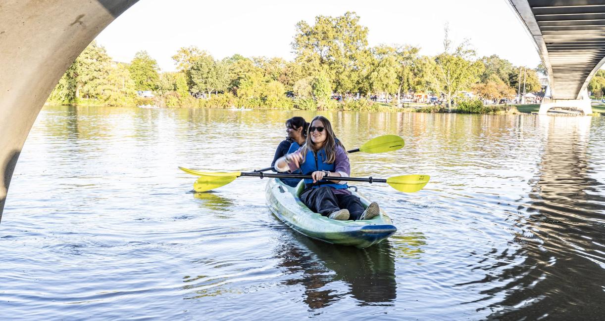 Kayakers are paddling under a bridge