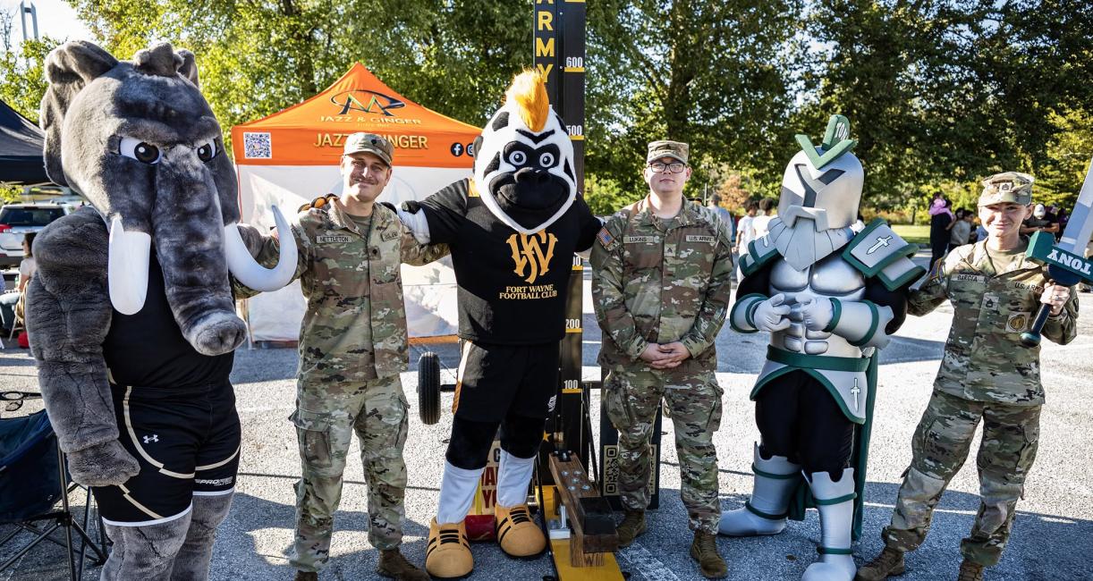 Several mascots with members of the military