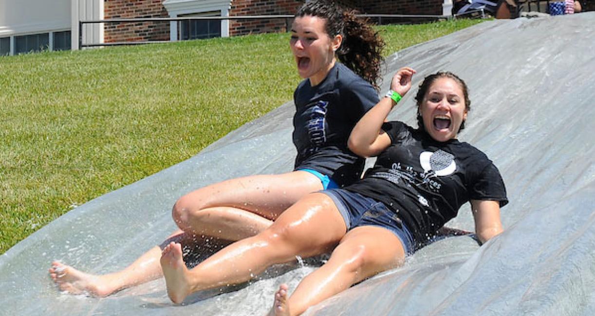 Two female students on a water slide during field day